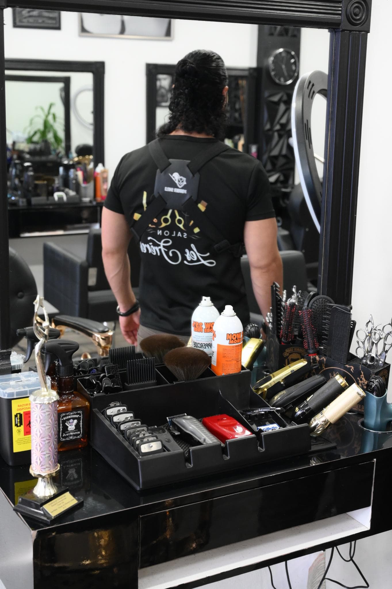 Barbier professionnel préparant son poste et ses outils au Salon Les Frères à Laval