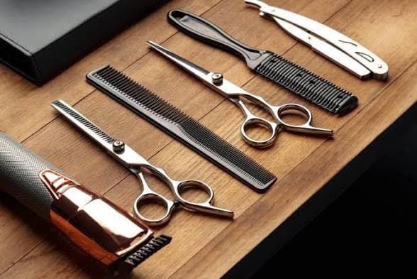 Barber scissors, combs, straight razor and clipper on a wooden station - Salon Les Frères is hiring in Laval
